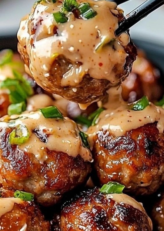 korean bbq meatballs with glaze and spicy mayo dip on a white platter