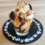 oreo ice cream sundae with chocolate sauce and whipped cream in a dessert glass