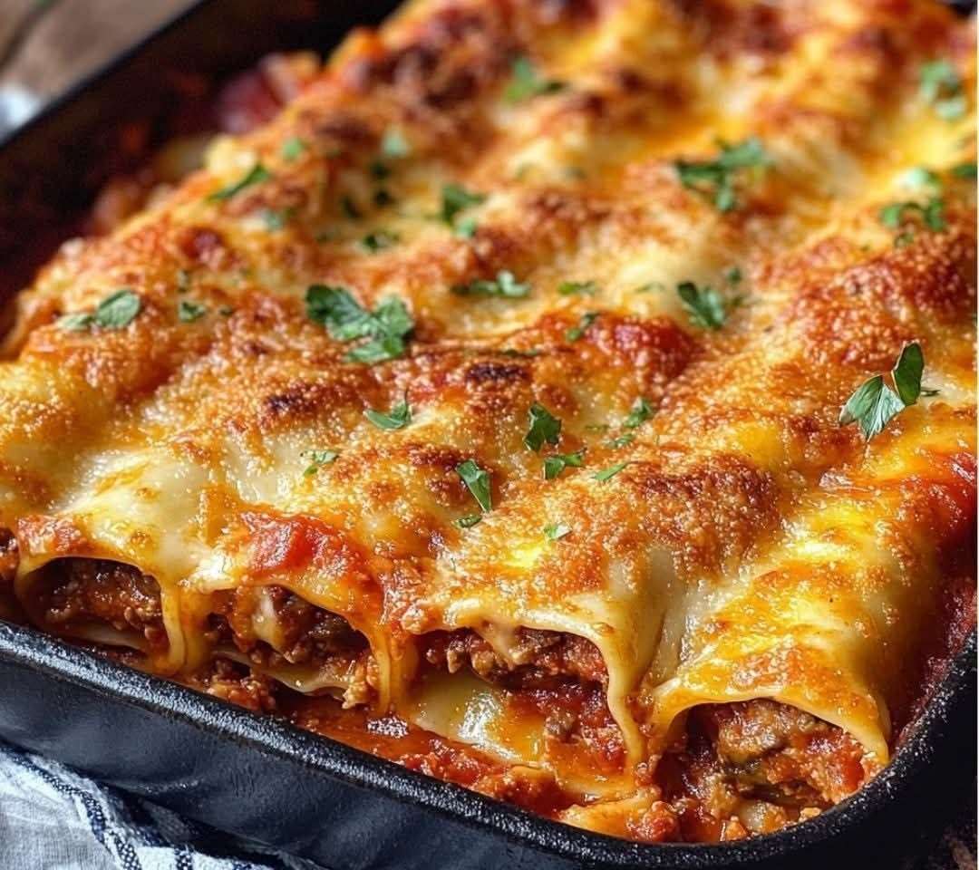 Baked Sicilian-style cannelloni filled with beef, ricotta and herbs, topped with melted mozzarella and Parmesan in a rich tomato sauce.