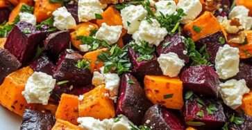 Roasted beet and sweet potato salad with feta cheese, walnuts and fresh parsley, tossed in a lemon vinaigrette and served in a bowl.