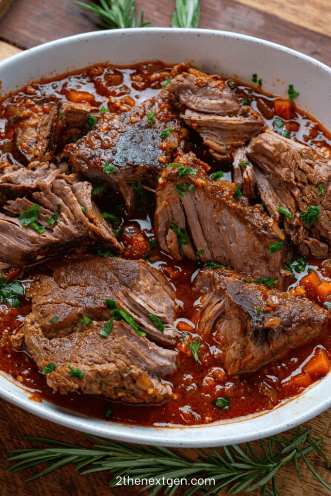 Italian stracotto pot roast braised in tomato and red wine sauce with carrots, celery and herbs served in a rustic Dutch oven.