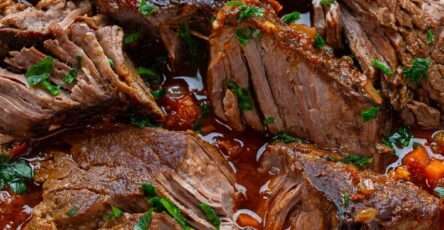 Italian stracotto pot roast braised in tomato and red wine sauce with carrots, celery and herbs served in a rustic Dutch oven.