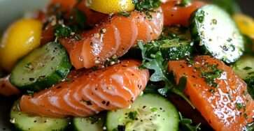 Fresh salad with lemon-marinated salmon cubes, crunchy cucumber slices, arugula, and fresh herbs