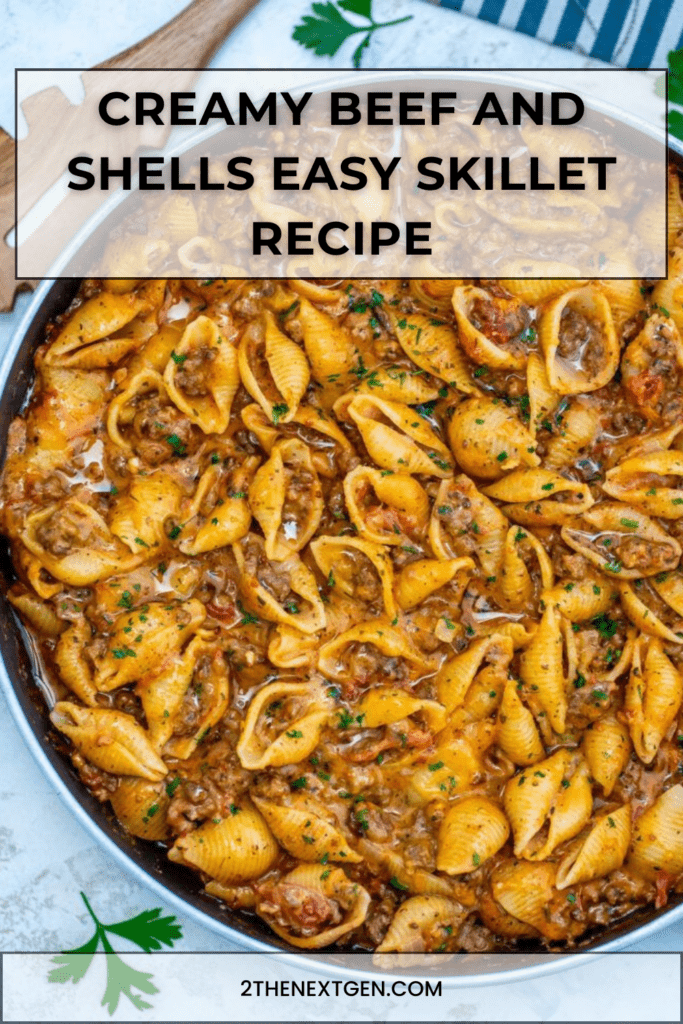 Creamy beef and shells pasta in a skillet with ground beef, tomato cream sauce, melted cheddar cheese, and fresh parsley garnish.