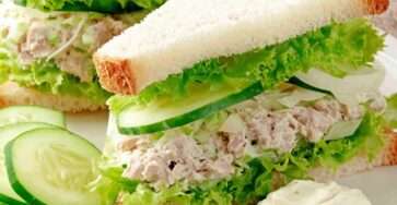 Mini tuna cucumber and lettuce appetizer sandwiches cut into triangles with creamy tuna filling and fresh cucumber slices