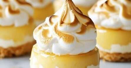Mini lemon meringue cheesecakes with a buttery biscuit crust, creamy lemon filling, tangy lemon curd layer, and toasted golden meringue topping.