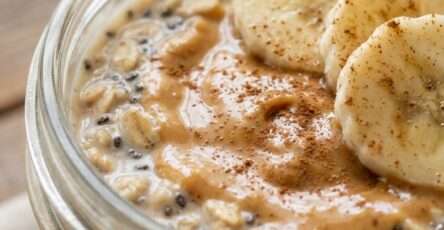 Healthy Breakfast Peanut butter banana overnight oats in a jar with creamy oats, banana slices, chia seeds, and a drizzle of peanut butter on top.