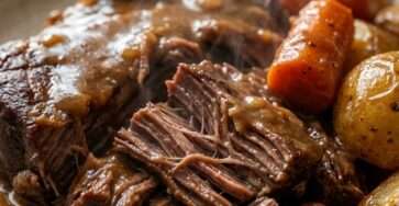 Classic Sunday Dinner pot roast in a Dutch oven with tender beef, carrots, and potatoes in a rich savory gravy, served hot on a rustic table.