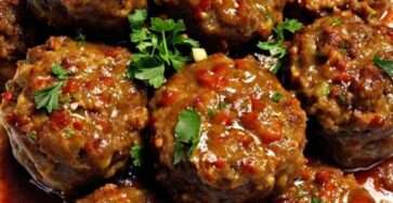 Tender beef meatballs in a rich tomato-based savory sauce, garnished with fresh parsley and served hot with a glossy, flavorful coating.