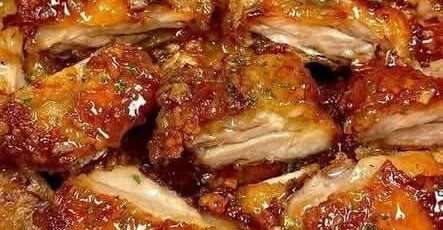 Crispy honey garlic chicken thighs sliced and served with sticky glaze, sesame seeds, green onions, and extra sauce on top.