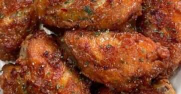 Crispy spicy chicken wings coated in sticky honey hot sauce glaze, sprinkled with parsley and chili flakes, served hot with dipping sauce.