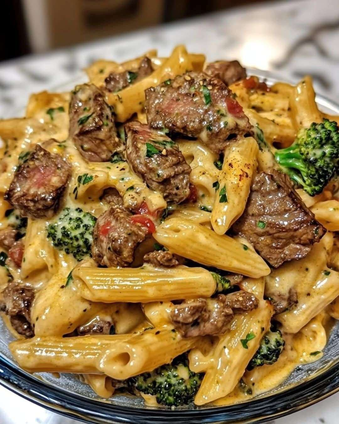 Creamy steak and broccoli penne pasta served with tender steak bites, cheddar parmesan sauce, fresh parsley, and extra cheese.