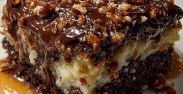 Chocolate coconut pecan caramel cake with moist chocolate cake, coconut pecan filling, glossy chocolate topping, chopped pecans, and caramel drizzle.