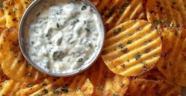 Crispy seasoned potato chips served warm with creamy garlic herb dip, fresh parsley, grated parmesan, and golden edges.