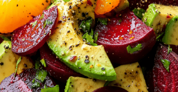 Colorful beet avocado orange salad served with sliced cooked beets, creamy avocado wedges, juicy orange segments, fresh herbs, and citrus dressing.