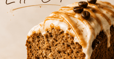 Close-up of banana bread latte cake slice with moist banana crumb, cinnamon coffee glaze, caramel drizzle, chopped walnuts, and a warm coffee cup in the background.