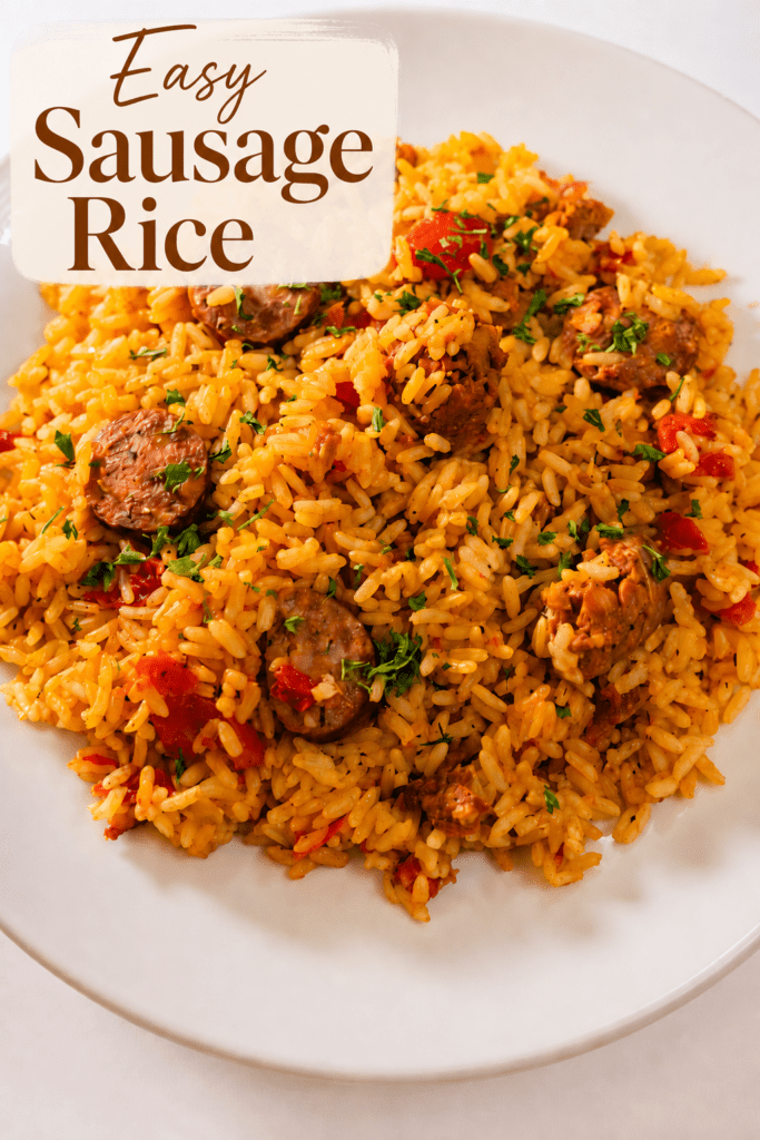 A hearty sausage chicken rice skillet served hot with fluffy yellow rice, browned chicken pieces, smoked sausage slices, red bell pepper, parsley, and lemon wedges.