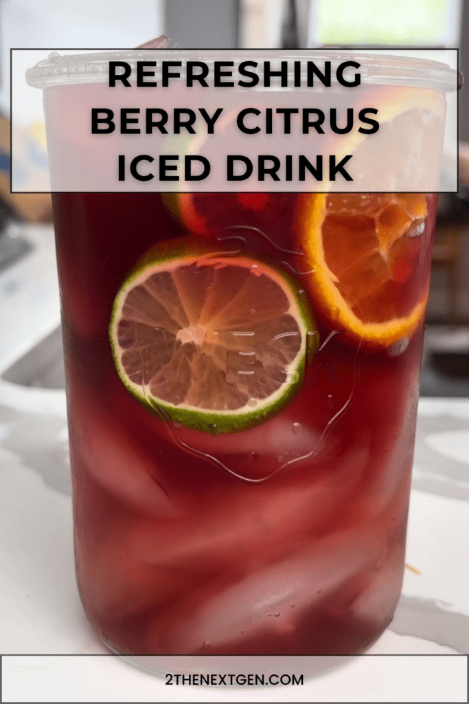 Refreshing berry citrus iced drink served with orange, lemon, lime slices, fresh berries, mint leaves, ice cubes, and sparkling water.