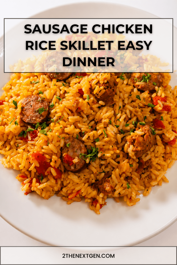 A hearty sausage chicken rice skillet served hot with fluffy yellow rice, browned chicken pieces, smoked sausage slices, red bell pepper, parsley, and lemon wedges.