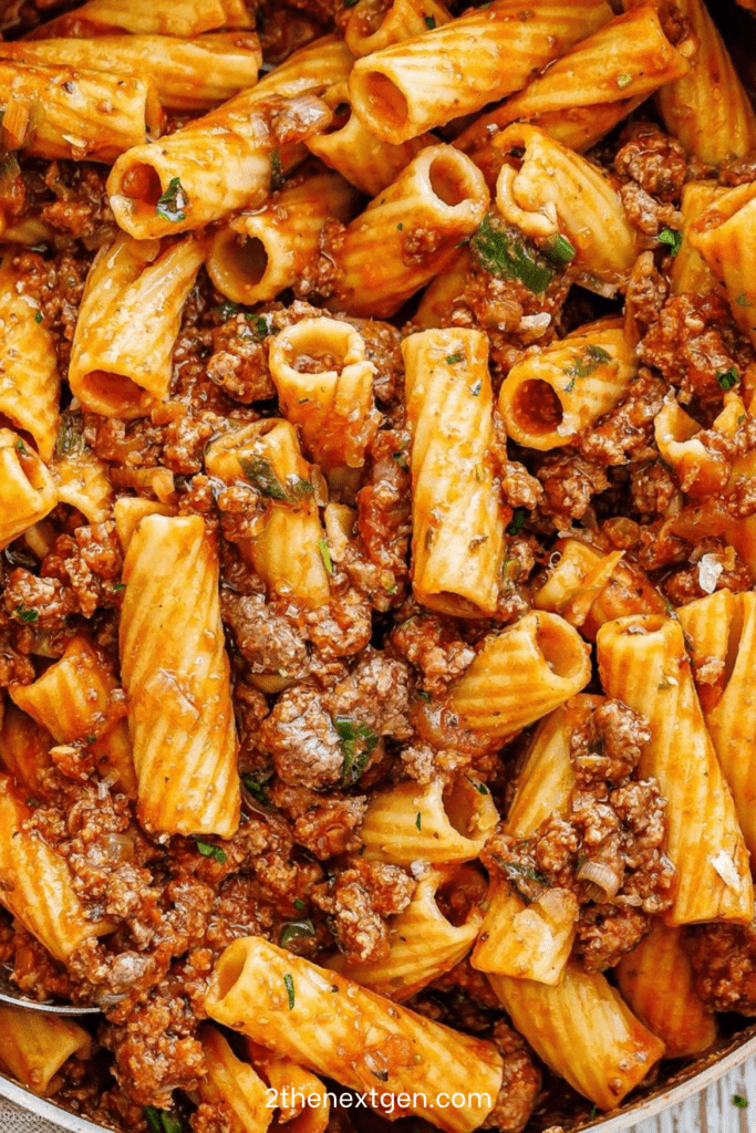 Beef rigatoni with rich tomato sauce served with grated parmesan, fresh parsley, black pepper, and tender ground beef sauce.