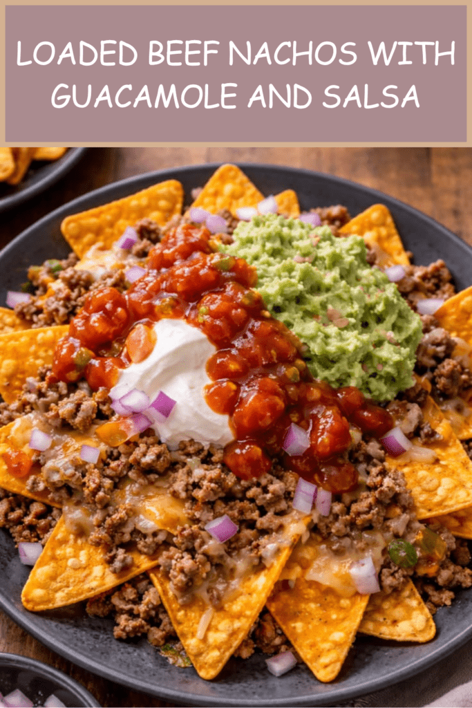Loaded beef nachos served on a tray with crispy tortilla chips, seasoned ground beef, melted cheddar, guacamole, salsa, sour cream, red onion, jalapeños, and fresh cilantro.