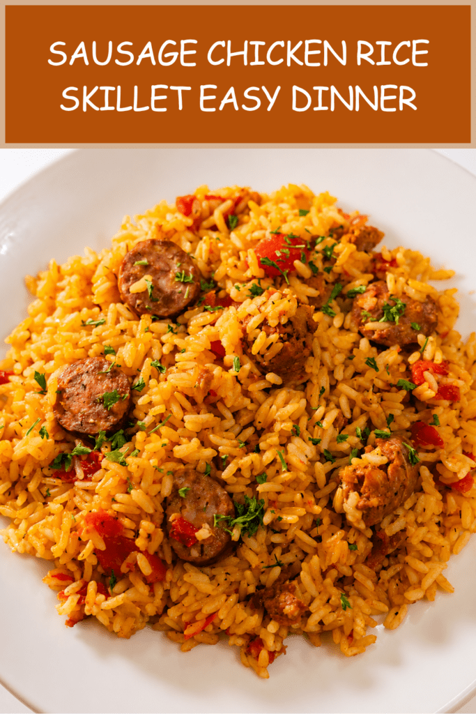 A hearty sausage chicken rice skillet served hot with fluffy yellow rice, browned chicken pieces, smoked sausage slices, red bell pepper, parsley, and lemon wedges.
