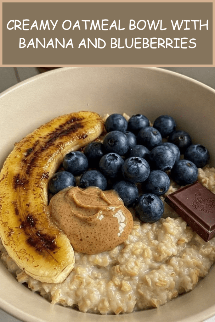 Creamy oatmeal bowl topped with caramelized banana halves, fresh blueberries, peanut butter, dark chocolate, and a drizzle of honey.