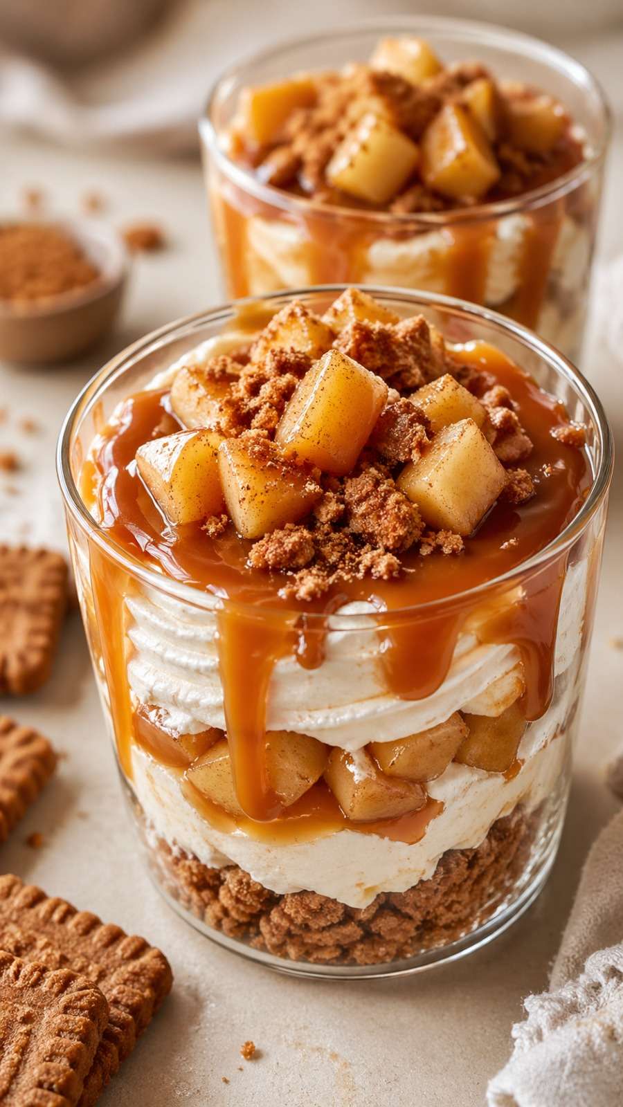 Caramel apple speculoos dessert cups layered with mascarpone cream, caramelized cinnamon apples, crushed Biscoff cookies, and caramel sauce.