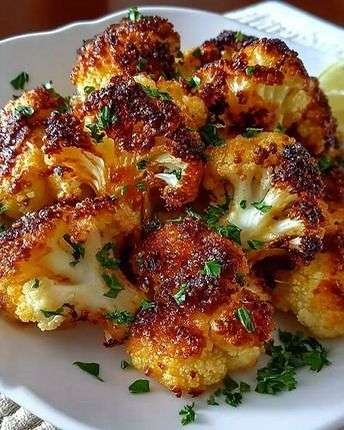 Crispy roasted cauliflower florets served golden with parmesan, garlic, paprika, fresh parsley, lemon juice, and crispy roasted edges.
