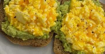 Crispy avocado egg toast made with mashed avocado, chunky chopped boiled eggs, whole grain bread, black pepper, chili flakes, and fresh lemon flavor.