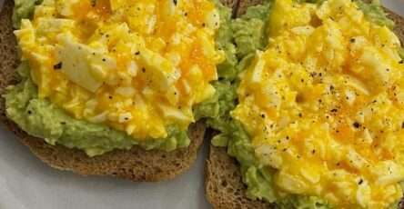 Crispy avocado egg toast made with mashed avocado, chunky chopped boiled eggs, whole grain bread, black pepper, chili flakes, and fresh lemon flavor.