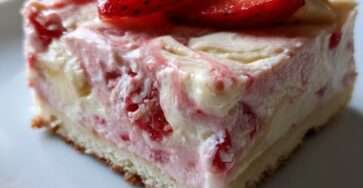 Chilled strawberry banana cottage cheese cheesecake bars sliced into squares with fresh strawberries, creamy filling, and a smooth frozen texture.