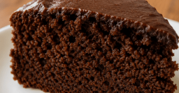 A moist sugar-free cacao banana blender cake sliced on a plate, made with almond flour, cocoa powder, banana flavor, and a soft chocolate crumb.
