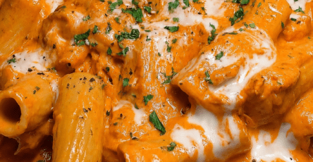 A creamy tomato chicken rigatoni dish served hot with tender chicken pieces, rich tomato cream sauce, melted mozzarella, parmesan, and fresh parsley.