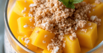 Creamy mango chia pudding served in clear glasses with coconut chia pudding, smooth mango purée, fresh mango cubes, granola, and mint leaves.