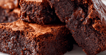 Fudgy chocolate brownies cut into squares with a crackly top, gooey chocolate center and rich dark chocolate texture.