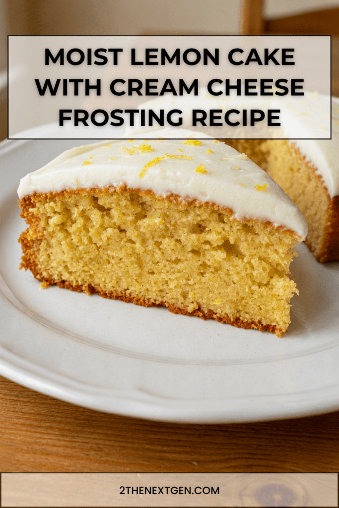A soft lemon cake topped with smooth cream cheese frosting, fresh lemon zest and a moist golden crumb served on a cake plate.