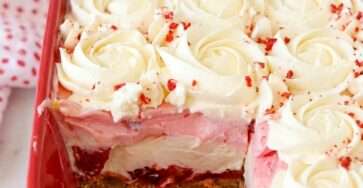 Sugar-free no-bake strawberry delight with graham cracker crust, sliced strawberries, creamy cheesecake filling, pink strawberry layer, and whipped cream topping.