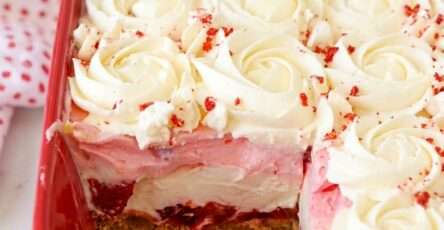 Sugar-free no-bake strawberry delight with graham cracker crust, sliced strawberries, creamy cheesecake filling, pink strawberry layer, and whipped cream topping.