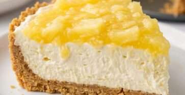 Creamy sugar-free no-bake pineapple cheesecake dessert in a graham cracker crust, topped with crushed pineapple and served chilled on a plate.
