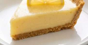 Creamy sugar-free condensed milk lemon pie with a buttery graham cracker crust, glossy lemon filling, and a fresh lemon slice garnish.