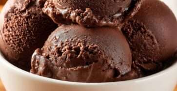 Rich sugar-free chocolate ice cream scooped into a plain white ceramic bowl with a dense creamy texture and deep chocolate color.