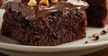 A square sugar-free chocolate hazelnut snack cake with creamy chocolate frosting, chopped hazelnuts, dark chocolate chips, and a rich cocoa crumb.