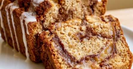 Sugar-free Amish mock apple fritter bread loaf sliced with cinnamon mock apple swirl, white glaze drizzle, and soft low-carb crumb.