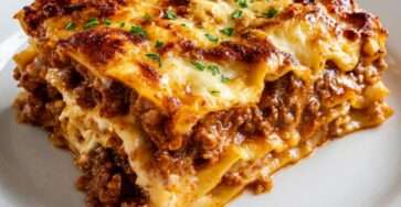 A golden baked homemade lasagna with rich meat sauce, creamy ricotta layers, melted mozzarella, Parmesan cheese, and perfectly sliced pasta layers.