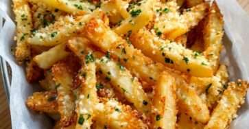 Golden oven-baked garlic Parmesan fries with crisp edges, fluffy centers, finely grated cheese, minced garlic, and fresh chopped parsley.