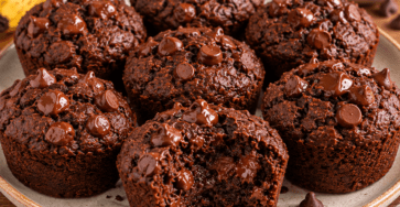 Fudgy banana brownie bites made with cocoa and nut butter, topped with chocolate chips and served on a plate with a soft, moist chocolate center.