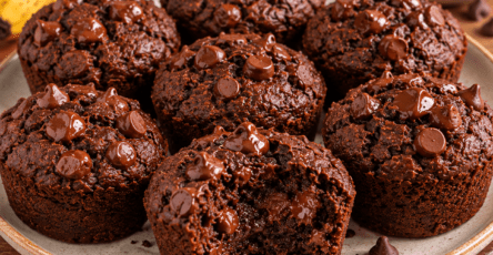 Fudgy banana brownie bites made with cocoa and nut butter, topped with chocolate chips and served on a plate with a soft, moist chocolate center.